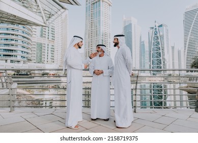 Three Business Men Walking In Dubai Wearing Traditional Emirati Clothes. Different Generation Business People Working Together