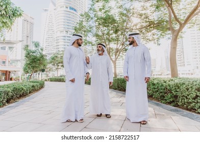 Three Business Men Walking In Dubai Wearing Traditional Emirati Clothes. Different Generation Business People Working Together