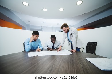 Three Business People In Conference Room 