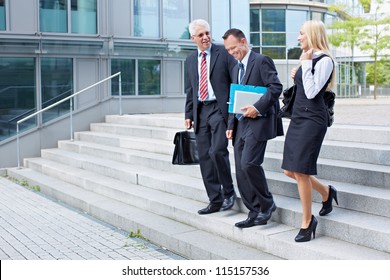 Three Business People Descending A Stairway And Talking