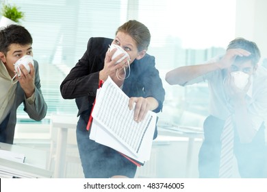 Three business people in gas masks gasping in office