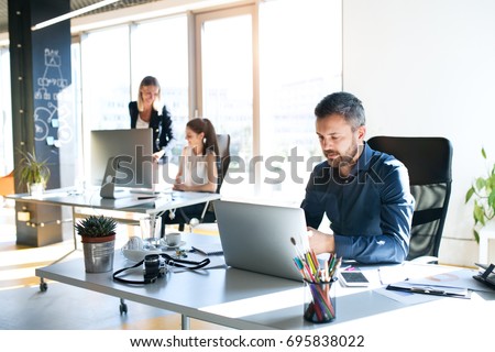 Three business people in the office working together.