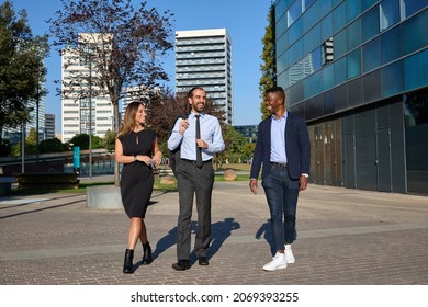 three business people walking down the street and laughing after workday