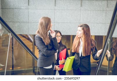 Three Business Women On The Escalator Going To Work.