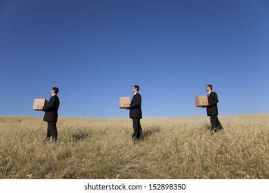 Three Businessman Lineup Holding A Cardboard Box Over His Head