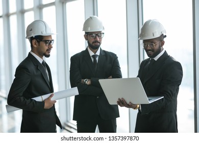 Three Businessmen In Ties And Hardhats Surprised With Window Scene. Property Investor Visiting Site And Impressed With Neighboring Construction.