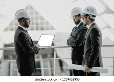 Three Businessmen In Ties And Hardhats Surprised With Window Scene. Property Investor Visiting Site And Impressed With Neighboring Construction.