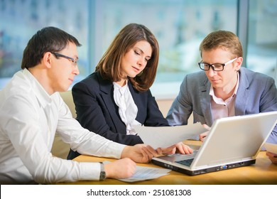 Three Businesspeople Interacting At Meeting