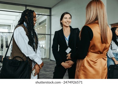 Three businesswomen networking, smiling, and conversing in a professional setting. Ideal for business, networking, and professional themes. - Powered by Shutterstock