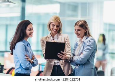 Three Businesswomen Talking In The Office. Happy Business Colleagues Standing In A Office