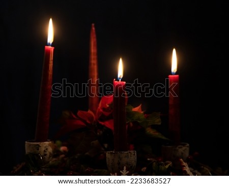 Three candles glow on Advent Wreath. Lighting the third candle on the third Sunday in December. Celebrating the beginning of Christmas holidays. Beautiful calm serene Christmas image.