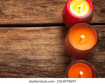  three candles sitting on top of a wooden table next to each other.  - Powered by Shutterstock