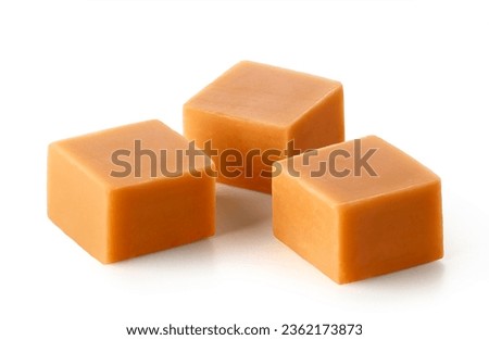 Three caramel candy cubes isolated on white background
