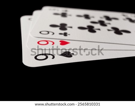 Three cards with the numbers 9 on them. The cards are arranged in a row. Poker cards