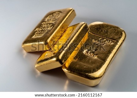 Three cast gold bars, the typical form of bullion. Selective focus.  