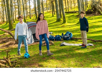 Three caucasian children paying football enjoying camping in the forest - Powered by Shutterstock