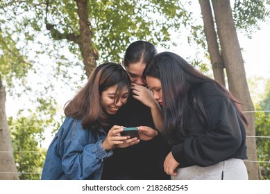 Three Chatty Friends Poke Fun At A Viral Post On Social Media While Outdoors. Watching A Silly Video On A Cellphone.