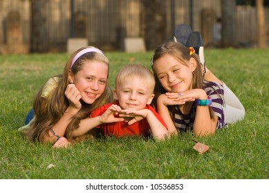 Three Children Lying On Grass On Stock Photo (Edit Now) 1473235457