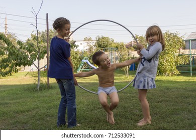 Three children play in the hoop park