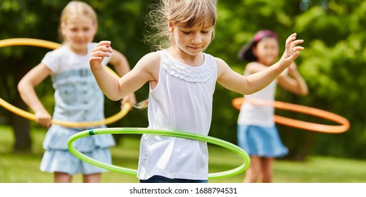 Three children play with tires in kindergarten in summer