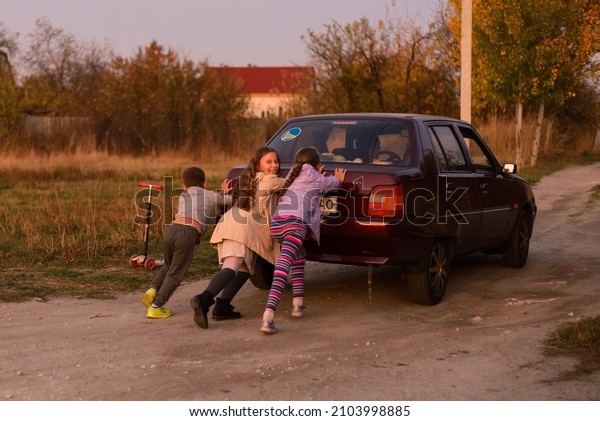 three children push the\
car