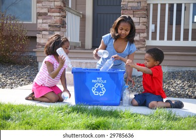 Three Children Putting Items Into Recycle Bin