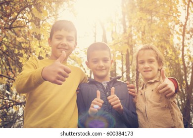 Three Children Showing Ok Sign In The Park.