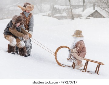 Three Children Sledding With Mountain Warm Winter Day