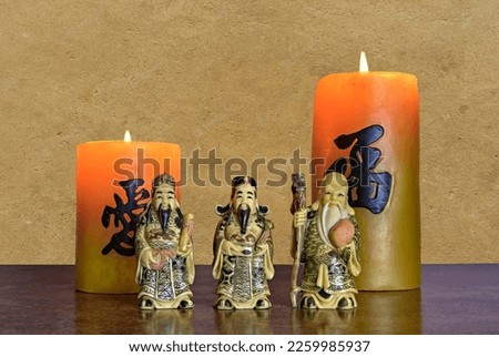 Three Chinese lucky gods.Fu Lu Shou.  The Three Star Gods of China.These represent happiness, prosperity, status and authority and health and longevity. With two candles reading Health and Happiness.
