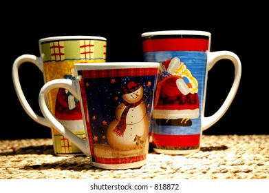 Three Christmas hot chocolate mugs on a straw mat.  Focus on the snowman. - Powered by Shutterstock