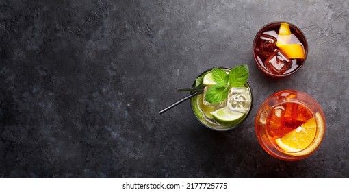 Three classic cocktail glasses on stone table. Negroni, aperol spritz and mojito. Top view with copy space. Flat lay - Powered by Shutterstock