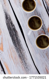 Three Coffee Cups On White Wood. Rustic Wooden Table. Flay Lay Top View.