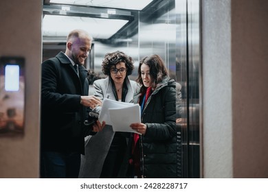 Three colleagues collaborating on project discussions near elevator in modern office. - Powered by Shutterstock