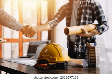 Three colleagues discussing data working and tablet, laptop with on on architectural project at construction site at desk in office - Powered by Shutterstock - Get 15% off with code: PIKWIZARD15