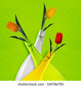 Three colored empty glass bottles and tulips.