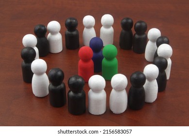 Three colored wooden figures as leaders surrounded by black and white figures. Concept of business leadership.