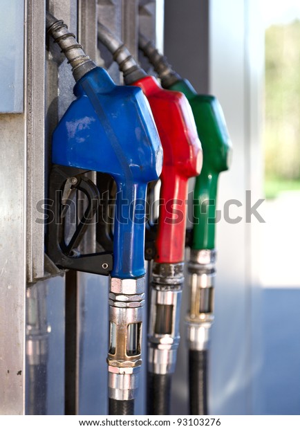 Three colorful\
pump nozzles at the gas\
station