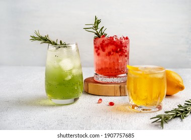 Three colorful summer cocktails in glasses on  white table. Assortment of fresh  summer drinks. Red sangria cocktails, orange punch cocktail, margarita cocktail, tropical mule.