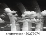 Three colossal ancient stone column rises up into the heavenly sky with swirling cloud in monochrome.