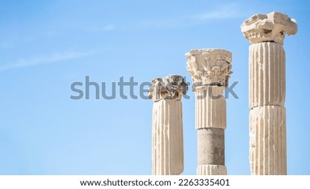 Three columns with corinthian capitals (partially ruined) in Ancient Ephesus. Sky an background. Selected focus, copy space. Art, design or tourism concept. Selcuk, Turkey (Turkiye)