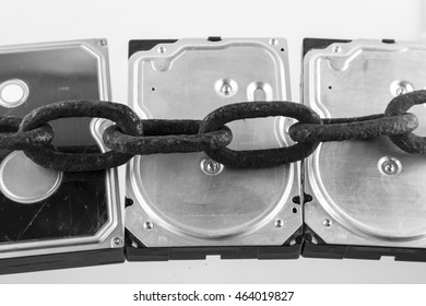 Three computer hard disk drives locked up with large rusty chain