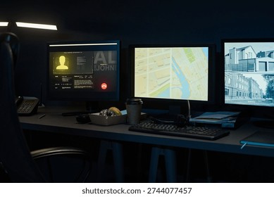 Three computer monitors displaying digital map, surveillance footage, and user profile on dark desk with keyboard, telephone, takeaway coffee cup and pastry box in modern workspace