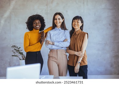 Three confident businesswomen posing together in a modern office. They exude professionalism and camaraderie, representing diversity and teamwork. Ideal for concepts of leadership and collaboration. - Powered by Shutterstock