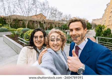 Three confident professionals smiling while taking a selfie in an urban park. teamwork, networking, and positive work relationships concept. Lifestyle, business.