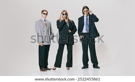 Three confident professionals stand tall in oversized suits and sharp ties, combining classic business style with bold, modern edge. Concept of corporate culture, business and style, leadership. Ad