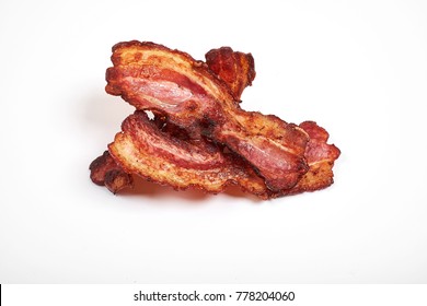 Three cooked, crispy fried bacon isolated on a white background.