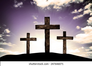 Three crosses on a hill and dark sky with sun rays 