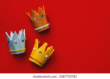 Three crowns of the three wise men with copy space over red background. Concept for Reyes Magos day. Three Wise Men concept