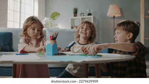 Three cute little caucasian children drawing  Young brothers   sisters playing and pencils together at home    happy family   childhood concept 