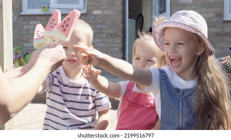 Three Cute Little Children Enjoys Delicious Ice Cream Cone. Child Eating Watermelon Popsicle. Kids Siblings Snack Sweets In Home Garden. Summer Holiday Hot Weather Sunny Day. Childhood, Food Candy